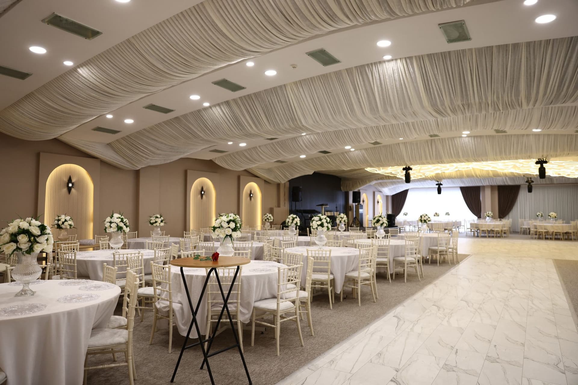 Salón amplio montado con mesas redondas y sillas Tiffany